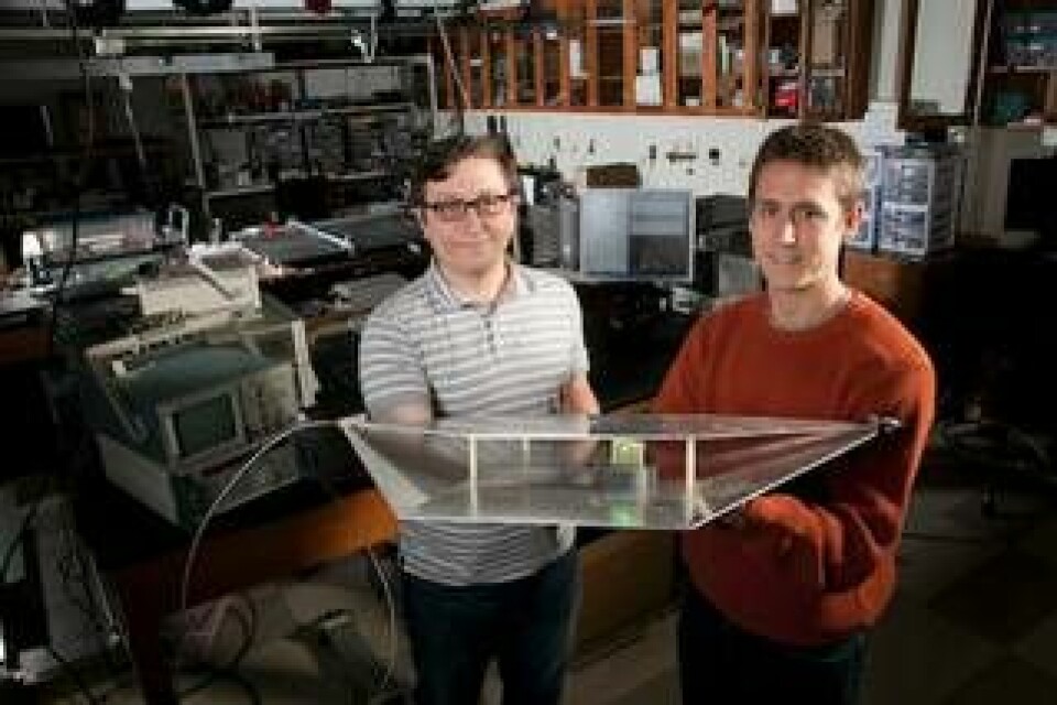Ingenjörsstudenterna Alexander Katko och Allen Hawkes visar en antennkonstruktion med en enda cell av metamaterial för infångande av radiovågor. Cellen ger tillräckligt med energi för att driva den gröna lysdioden. Foto: Duke University