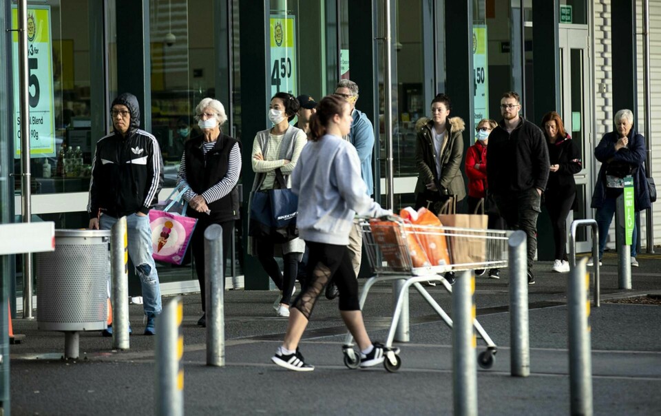 Människor köar utanför en livsmedelsbutik i Auckland. Foto: Dean Purcell/AP/TT