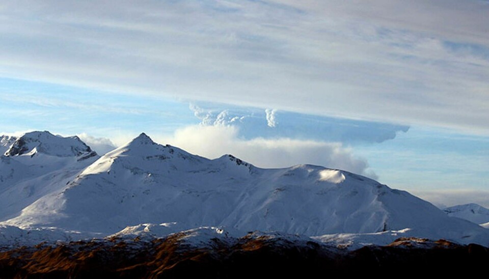 Bild från de Aleutiska öarna i Alaska. Molnet bakom berget kommer från ett vulkanutbrott, har alltså inget med texten att göra. Foto: TT