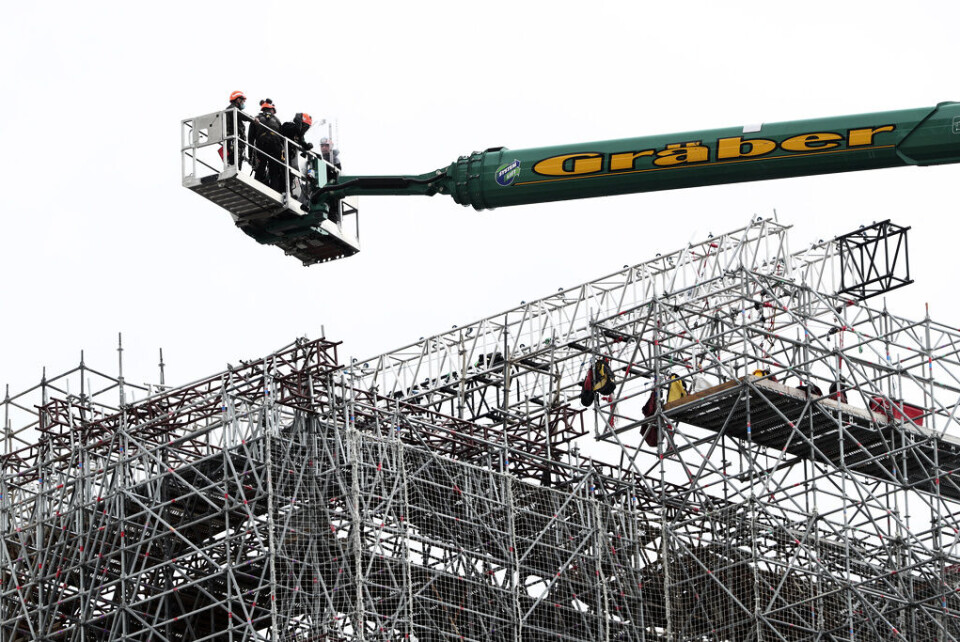 Arbetare lyftes upp till Notre-Dame för att inleda arbetet med att avlägsna de smälta byggnadsställningarna under måndagen. Foto: Thibault Camus Arbetare lyftes upp till Notre-Dame för att inleda arbetet med att avlägsna de smälta byggnadsställningarna under måndagen. Foto: Thibault Camus