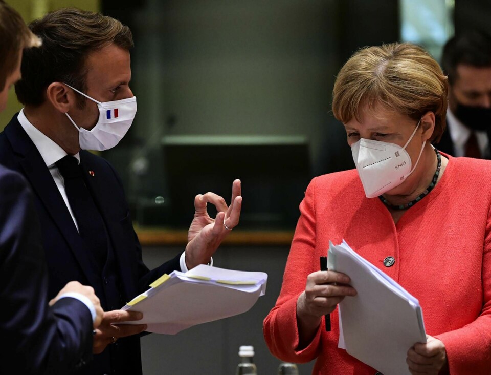 Frankrikes president Emmanuel Macron och Tysklands förbundskansler Angela Merkel studerar ett utkast. Foto: John Thys/AP/TT