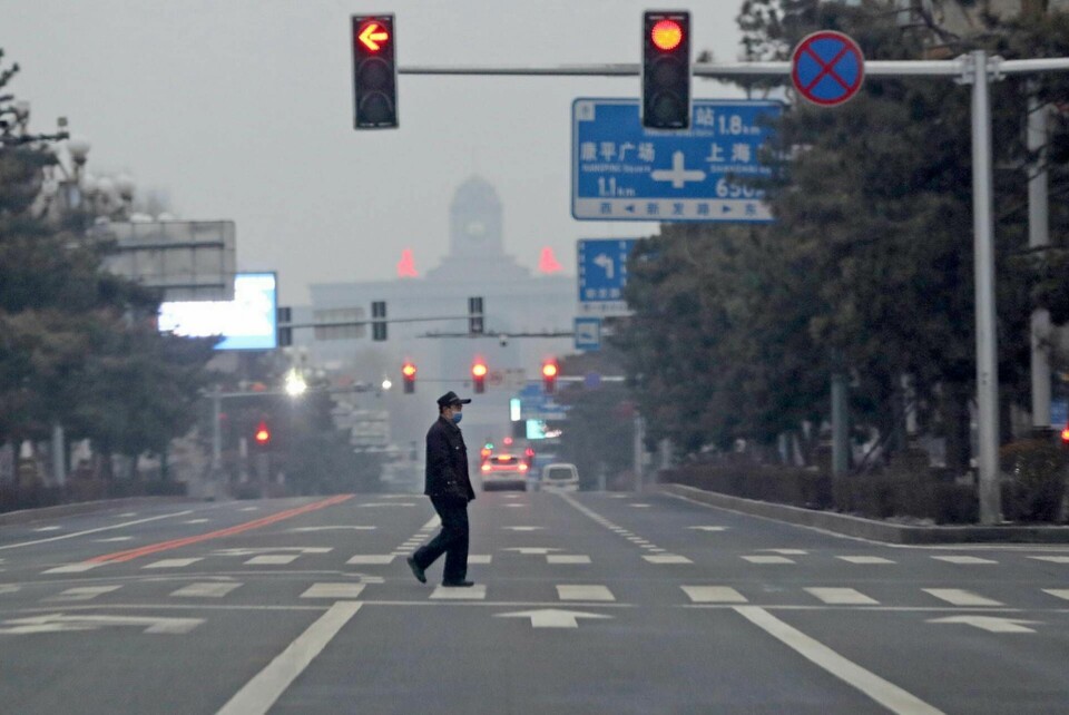 En man går över en gata i nedständga Changchun i nordöstra Kina. Bilden är från i måndags. Foto: Chinatopix/AP/TT
