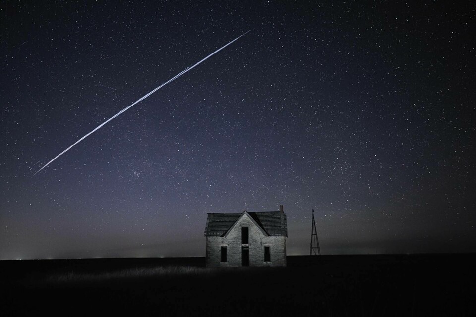 Den här bilden, tagen med lång slutartid, uppges visa en Starlinksatellit som passerar över ett hus i amerikanska Kansas. Foto: Reed Hoffmann/AP/TT
