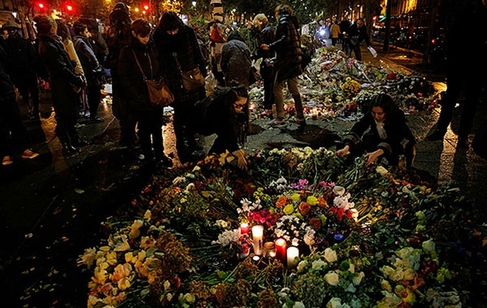 Parisbor lämnar blommor och ljus utanför konserthuset Bataclan där en av attackerna ägde rum. Foto: Christophe Ena / TT