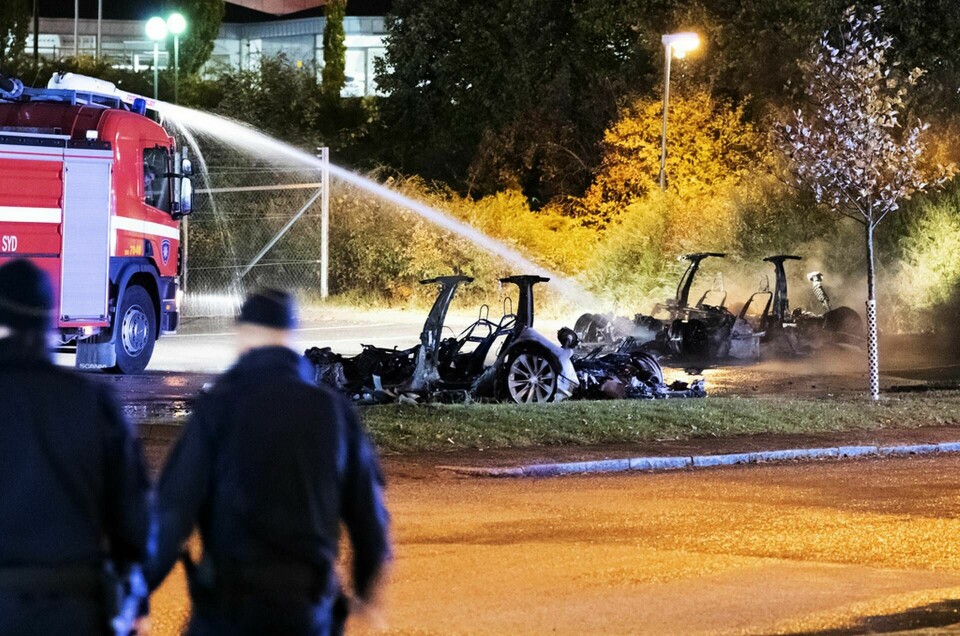 Polis och räddningstjänst på plats vid vraken efter de utbrända elbilarna utanför Teslas servicecenter i Malmö tidigt på tisdagsmorgonen. Foto: Johan Nilsson/TT
