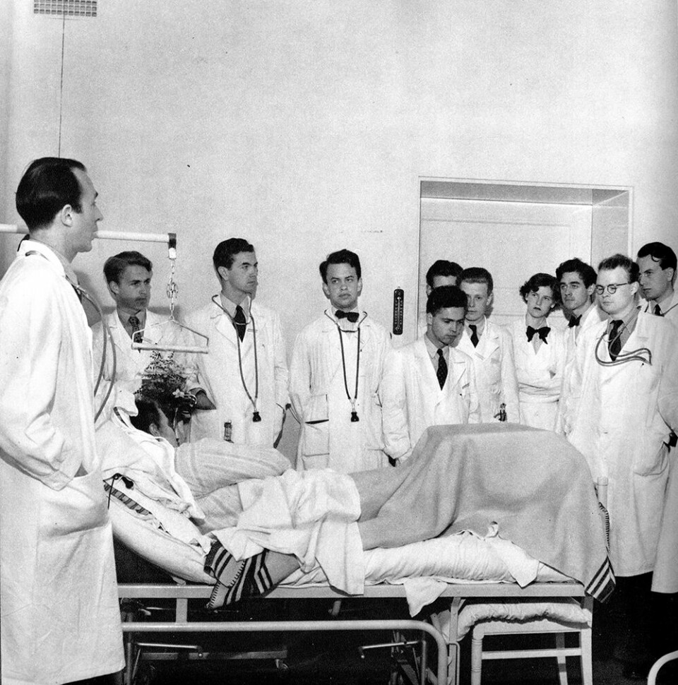 Docent Nils Alwall på medicinska kliniken undervisar en skara medicine kandidater vid en patientsäng i Lund, omkring år 1950. Foto: ERIK LILJEROTH/NORDISKA MUSEET/SYDSVENSKA MEDICINHISTORISKA SÄLLSKAPET