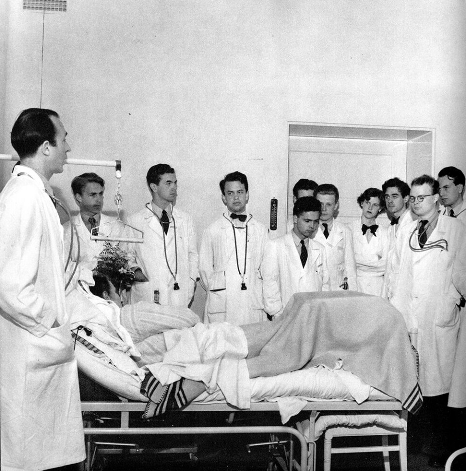 Docent Nils Alwall på medicinska kliniken undervisar en skara medicine kandidater vid en patientsäng i Lund, omkring år 1950. Foto: ERIK LILJEROTH/NORDISKA MUSEET/SYDSVENSKA MEDICINHISTORISKA SÄLLSKAPET Docent Nils Alwall på medicinska kliniken undervisar en skara medicine kandidater vid en patientsäng i Lund, omkring år 1950. Foto: ERIK LILJEROTH/NORDISKA MUSEET/SYDSVENSKA MEDICINHISTORISKA SÄLLSKAPET