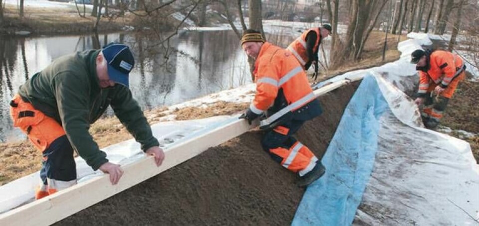 Personal från Tekniska kontoret bygger skyddsvallar längs med Lagan i Värnamo. Lagan är en av de floder som redan har stigit rejält. Foto: Scanpix