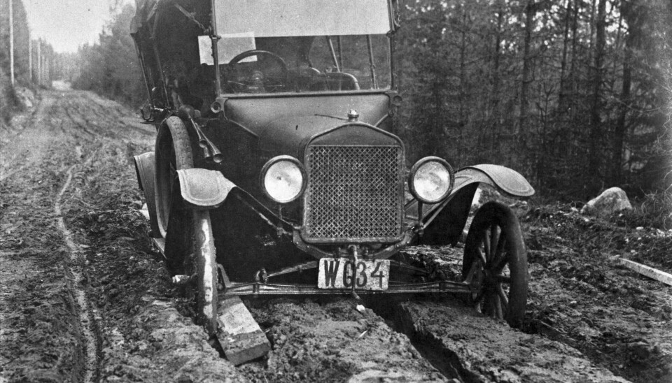 Svartvit bild på en T-ford som har kört fast i en decimetertjock lervällning.