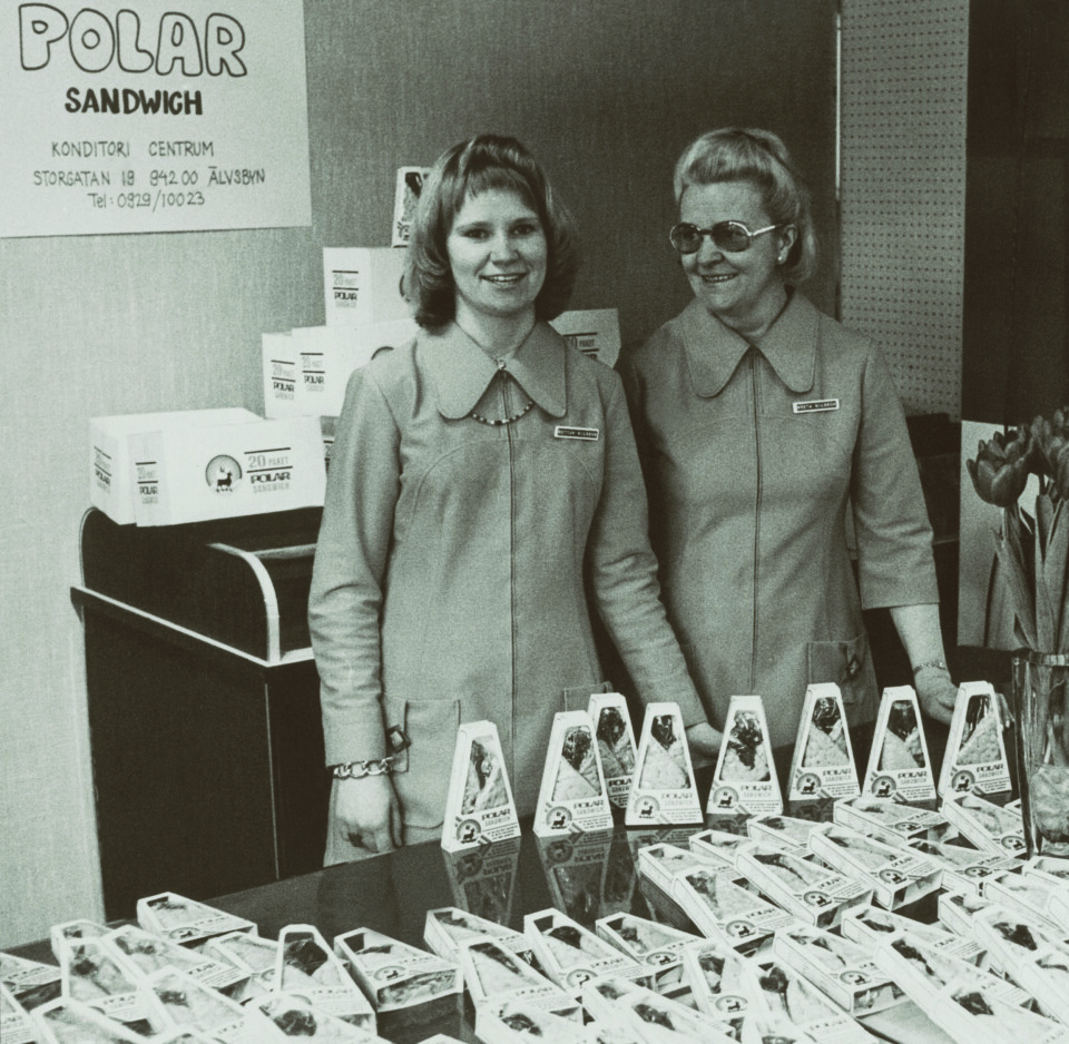 Greta Nilsson och dottern Elisabet demonstrerar Polar Sandwich på Norrlandscenter 1971. Renklämman blir världens första djupfrysta smörgås – och den blir snart framgångsrik. Smörgåsens pappask ska påminna om en samisk kåta.