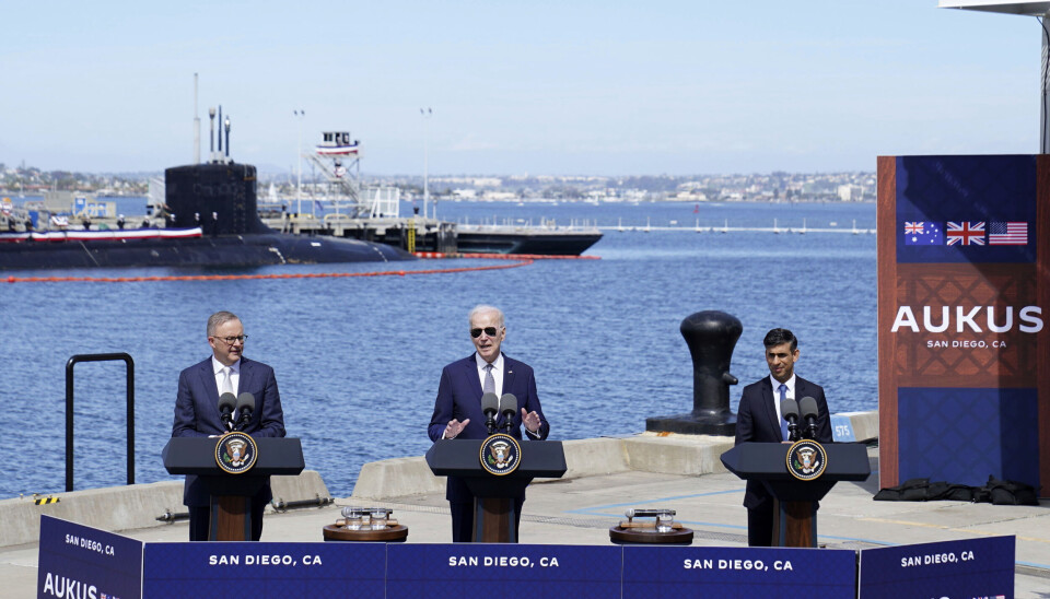 Australiens premiärminister Anthony Albanese, USA:s president Joe Biden och Storbritanniens premiärminister Rishi Sunak på flottbasen Point Loma i Kalifornien. Anthony Albanese och Joe Biden talar, i bakgrunden havet med en ubåt