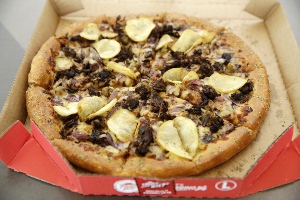 En pizza med gott om fyllning i en öppnad, röd Pizza Hut-kartong
