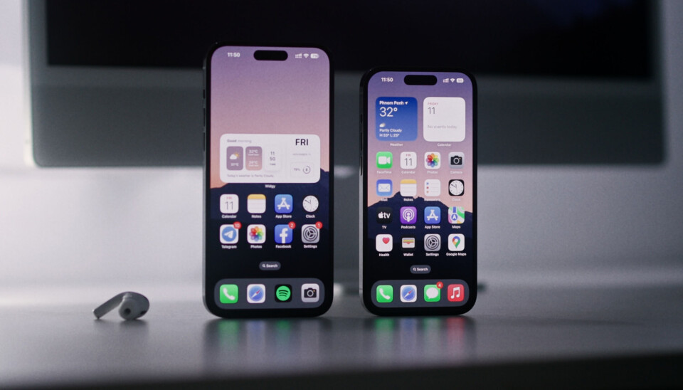 'Dynamic island' är uppmärksammad ny funktion som kom med Iphone 14 Pro. Om några år kommer alla Iphone ha finessen, siar analysfirman DCSS. Bilden visar hemskärmen på två Iphone 14 Pro-modeller, stående på högkant på ett bord. Intill telefonerna ligger en Airpod-hörlur.