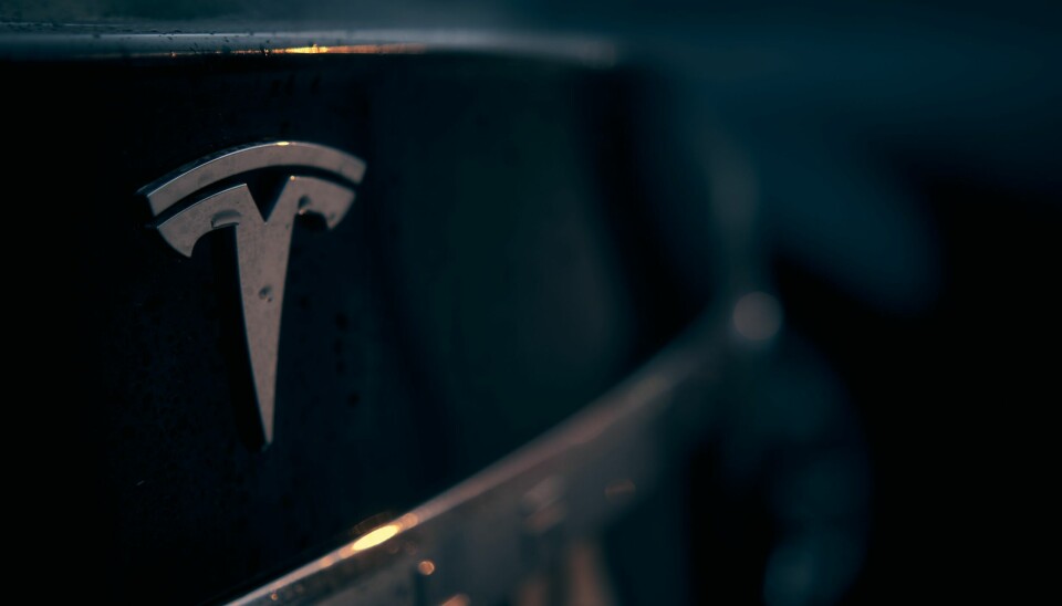 Tesla logo på en svart bil.