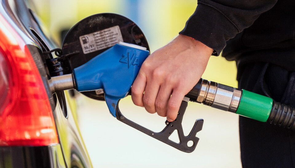 En hand som håller en pump för att tanka sin bil med bränsle