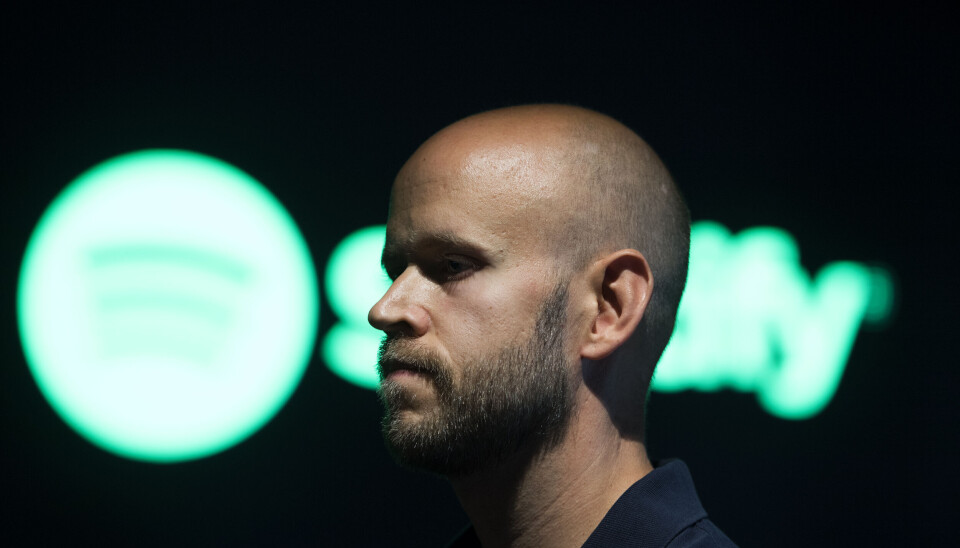 Spotifys grundare Daniel Ek är kritisk mot vad han beskriver som undermåligt konkurrensskydd på den digitala marknaden i USA. Arkivbild. Daniel Ek framför en grön Spotify-logga.