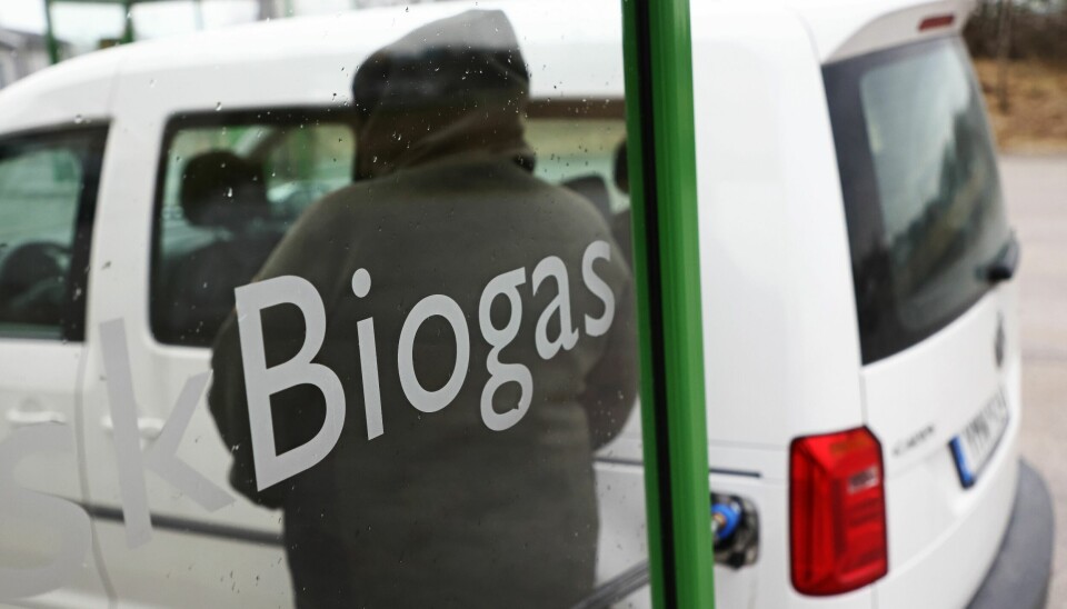 Vit bil vid en station för att tanka biogas.