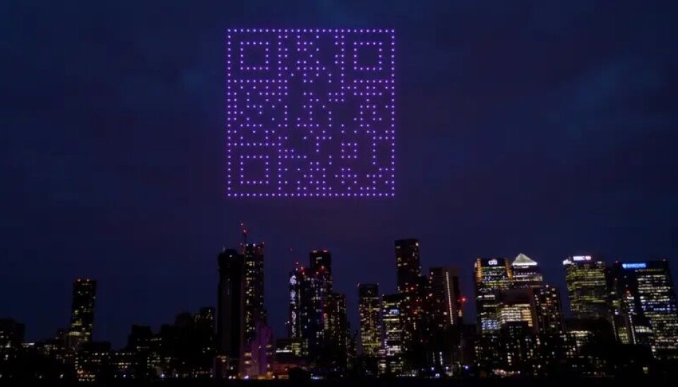 En lila qr-kod dök upp över London. En QR-kod över london som består av drönare.