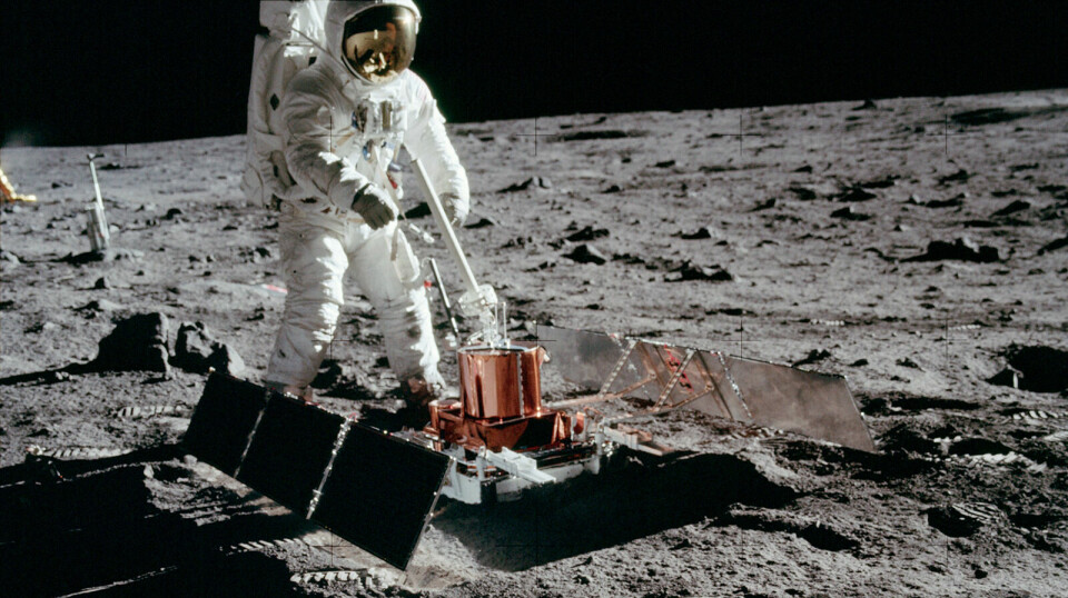 En astronaut på månen med ett instrument.