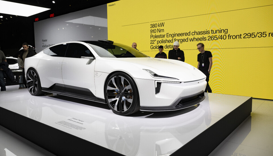 Polestar visar upp bil. Arkivbild En vit bil från Polestar framför en gul vägg med svart text på.