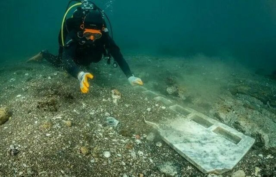 En dykare undersöker ett altare på havets botten.