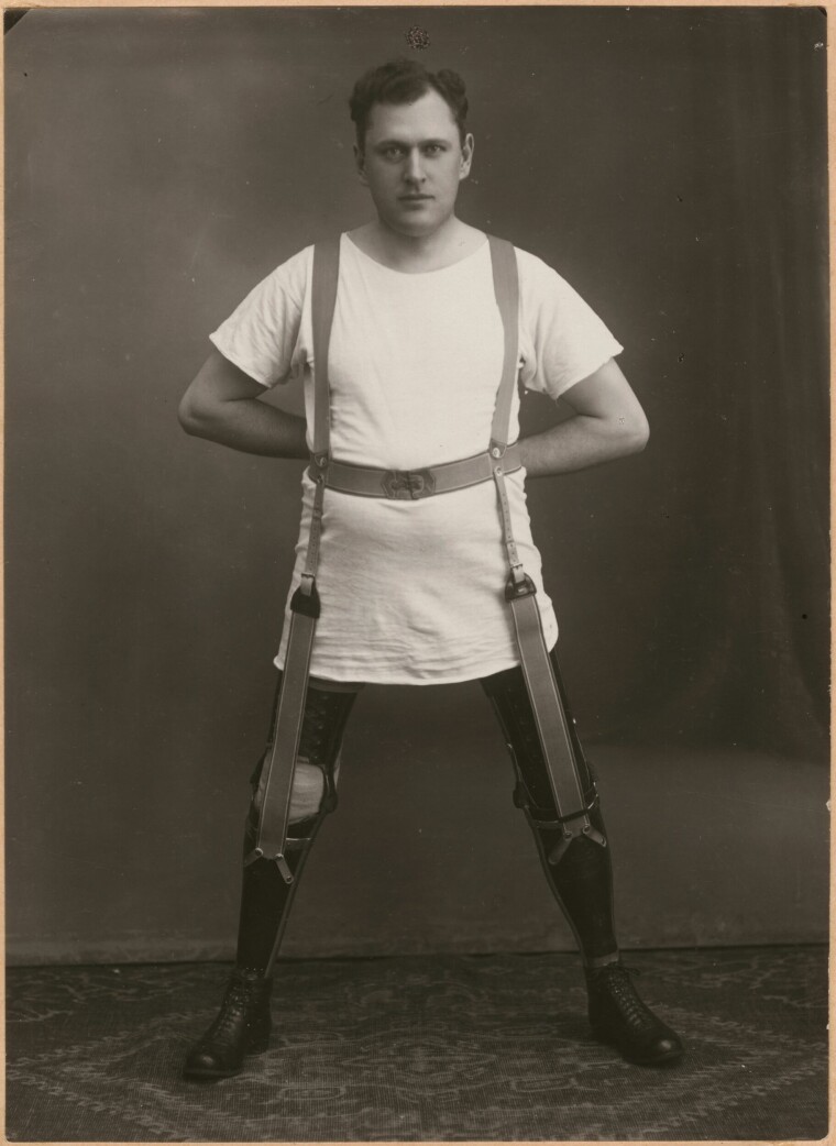 Sven Lundberg iklädd lång vit t-tröja så att hans benproteser syns. Han står stabilt och bredbent, proteserna är fastsatta i en sele runt överkroppen.