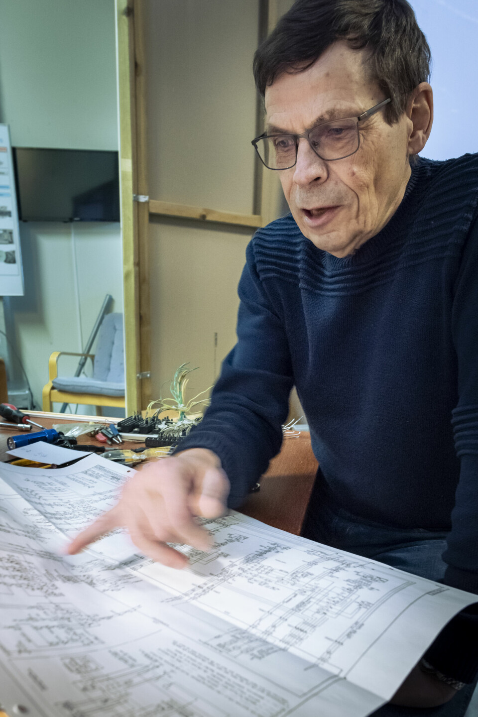 Markku Siipola tittar på ritningarna över Viggeninstrumenten.
