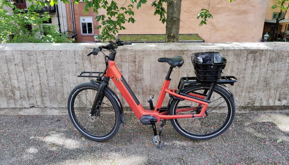 Elcykel med cykelkorg på pakethållaren.