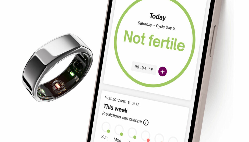 The picture shows the Finnish smart gadget Oura Ring, which can be used together with the pregnancy app Natural Cycles.  The picture also shows an iPhone with the Natural Cyle app.
