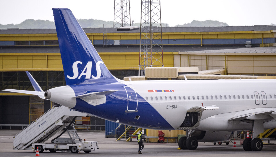 SAS hemsida utsattes under morgonen för en hackerattack. Flygplan på marken med blå bakvinge. I bakgrunden en gul byggnad.