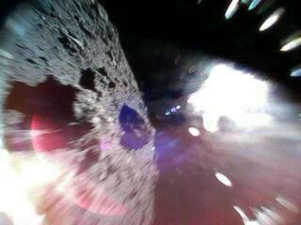 Rover 1A har fotat asteroiden Ryugus yta medan den hoppat sig fram. Till vänster syns asteroidens yta, det vita ljuset till höger beror på solljuset. Foto: Jaxa