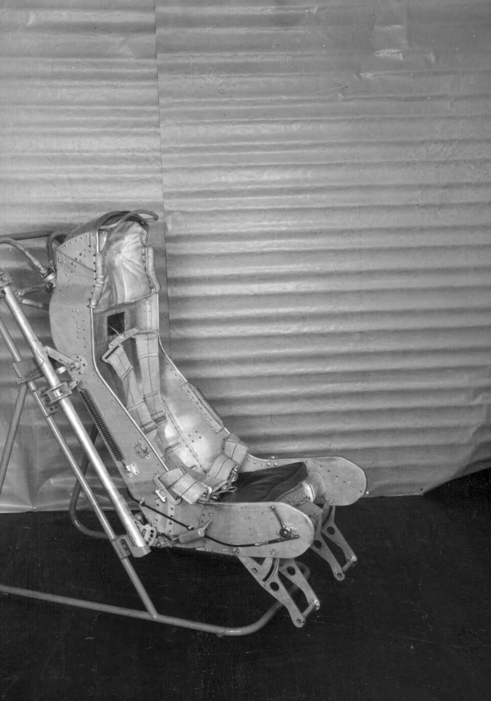 En tidig version av Lansens katapultstol. Det lilla handtaget på höger sida om stolbaljan är för att slacka på fastbindningsremmarna för att därigenom medge bättre rörlighet vid målspaning. Stolen förbättrades successivt, bland annat automatiserades hela utskjutningsförloppet.