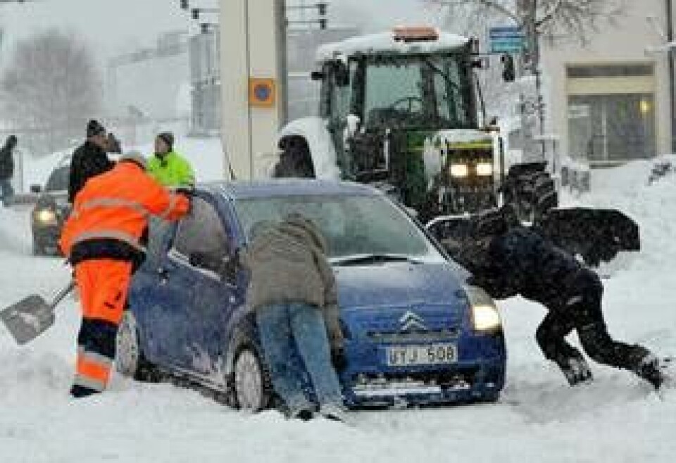 En bil får hjälp loss från snö och halka i Ärvinge i Kista i västra Stockholm i fredagens snökaos. Foto: Johan Nilsson/SCANPIX