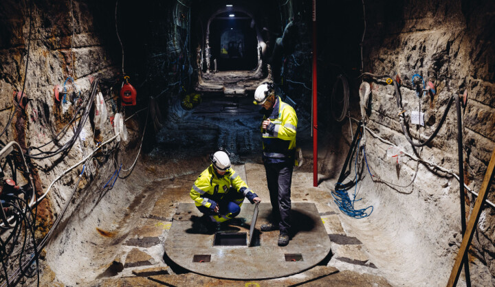 Två män i varselkläder syns i en bergtunnel.