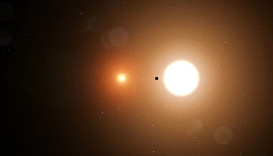 En illustration av TOI-1338b, den första planeten som hittades i det binära stjärnsystemet. En planet framför två stjärnor.