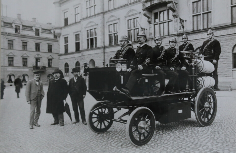 Vid Eskilstuna stadshus 1 augusti 1902. Till vänster med paraply brandchefen Eric Anton Berg, till höger om honom Hadar Hallström. Vid styrspaken brandchefen C J Pettersson. Foto: ESKILSTUNA MUSEERS ARKIV Vid Eskilstuna stadshus 1 augusti 1902. Till vänster med paraply brandchefen Eric Anton Berg, till höger om honom Hadar Hallström. Vid styrspaken brandchefen C J Pettersson. Foto: ESKILSTUNA MUSEERS ARKIV