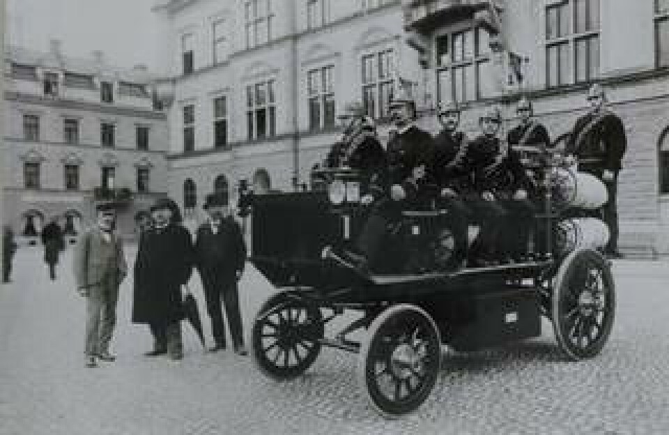 Vid Eskilstuna stadshus 1 augusti 1902. Till vänster med paraply brandchefen Eric Anton Berg, till höger om honom Hadar Hallström. Vid styrspaken brandchefen C J Pettersson. Foto: ESKILSTUNA MUSEERS ARKIV