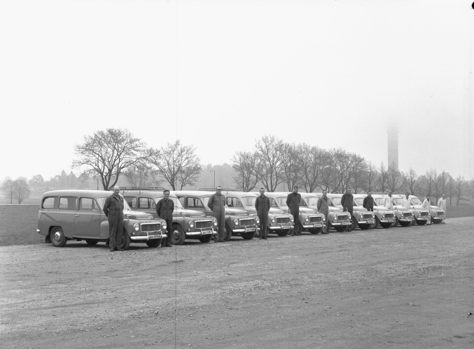 En prydligt parkerad rad av Volvo Duett med sina förare stående bredvid fronten.