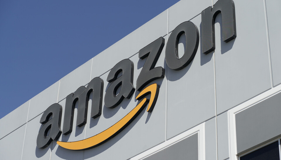Amazon har skickat ut en varning till de anställda som jobbar på distans för mycket. Arkivbild Svart Amazon-logga på en husfasad