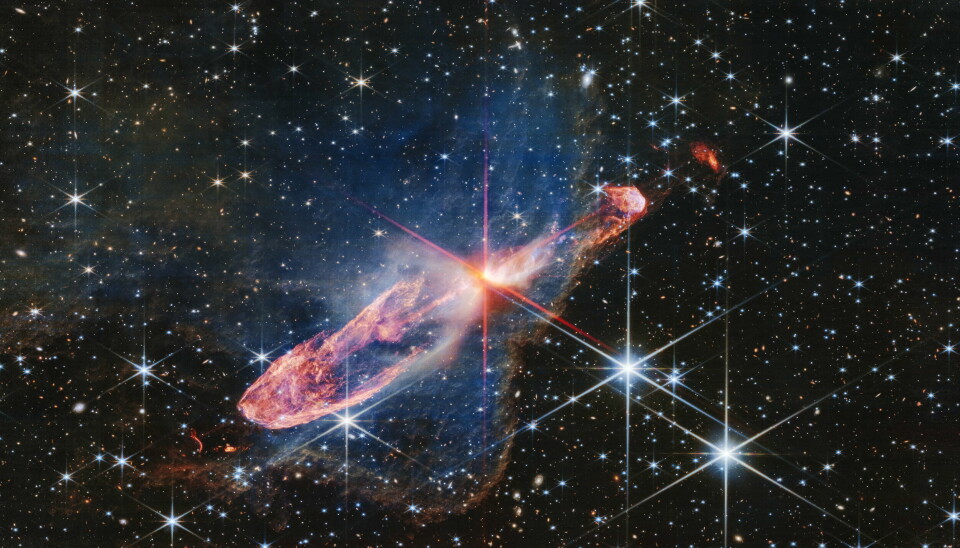 Stjärnorna Herbig-Haro 46/47, som befinner sig 1 470 ljusår bort, är i mitten av de röda 'linjerna'. Det så kallade frågetecknet är i nedre kanten av bilden, lite till höger om mitten.