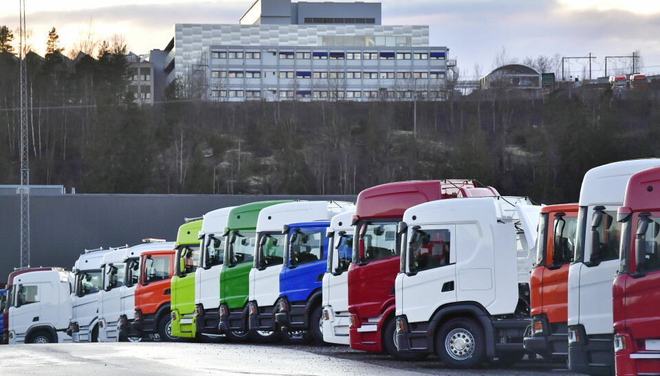 Lastbilar i flera färger som står parkerade på rad.