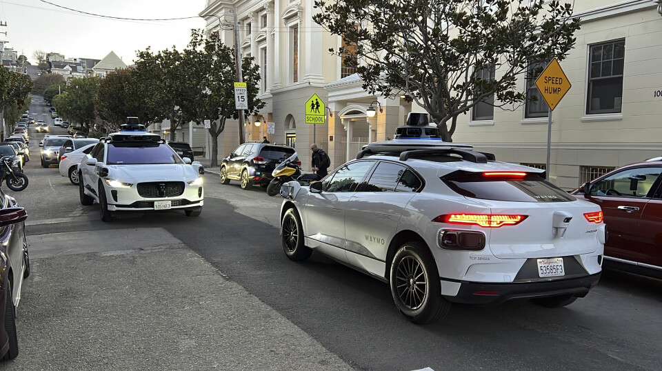 Två självkörande taxibilar tillhörande Waymo möts på en gata i San Francisco.