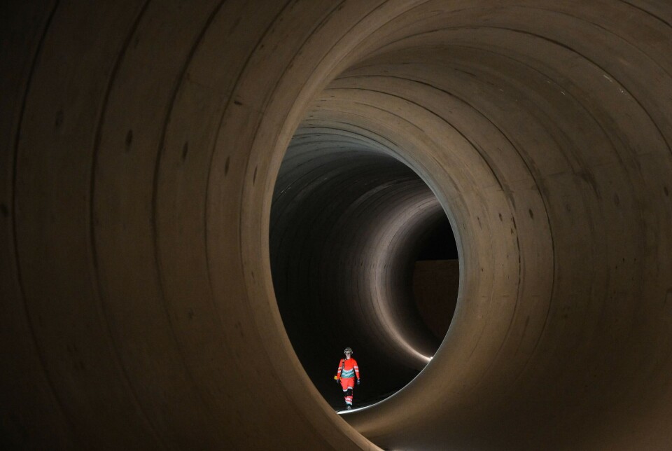 Än så länge är 'superkloaken' ren och fin. Bild tagen under byggarbete i tunneln i juni i år. En person med orange kläder i ett stort rör