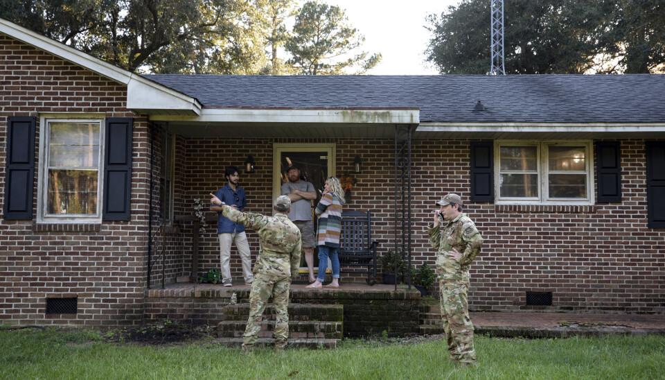 Personal från det amerikanska flygvapnets bas i Charleston på plats i området där vrakdelar från ett saknat stridsplan av typen F 35 återfunnits. Arkivbild. Personer klädda i kamouflagekläder i en grön trädgård framför ett brunt tegelhus