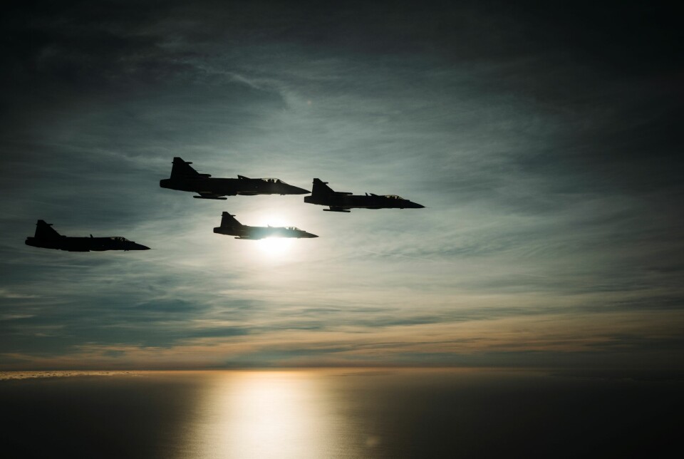 Fyra stridsflygplan flyger över hav.