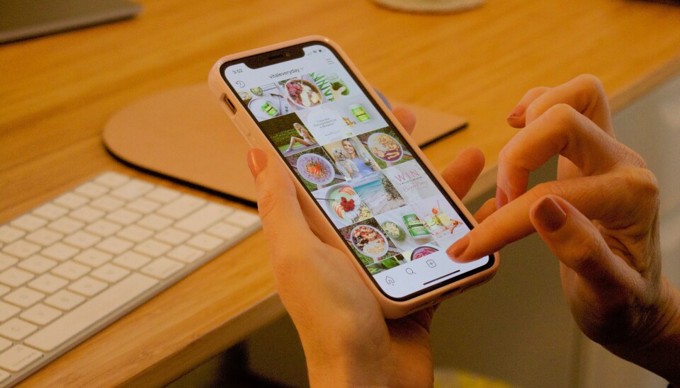 Meta kan inom kort komma att rulla ut betalversioner av Instagram och Facebook. Arkivbild. Två händer som navigerar på en mobiltelefon