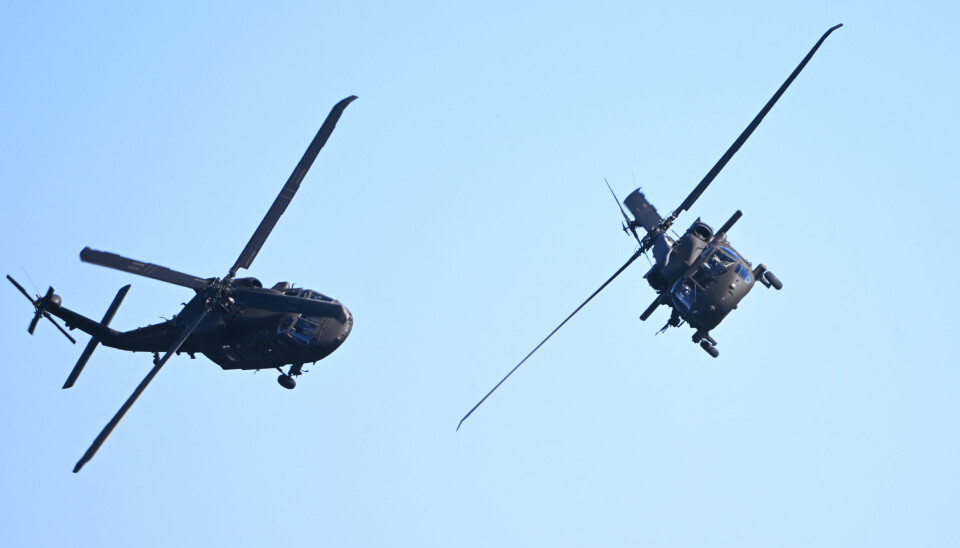 Två helikoptrar i luften blå himmel bakom