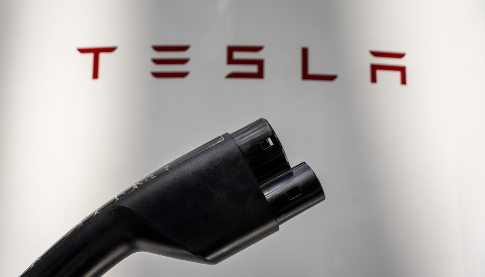 Totalt berörs ungefär 130 anställda på sju orter, enligt fackförbundet. En svart laddare för elbil framför en text där det står Tesla