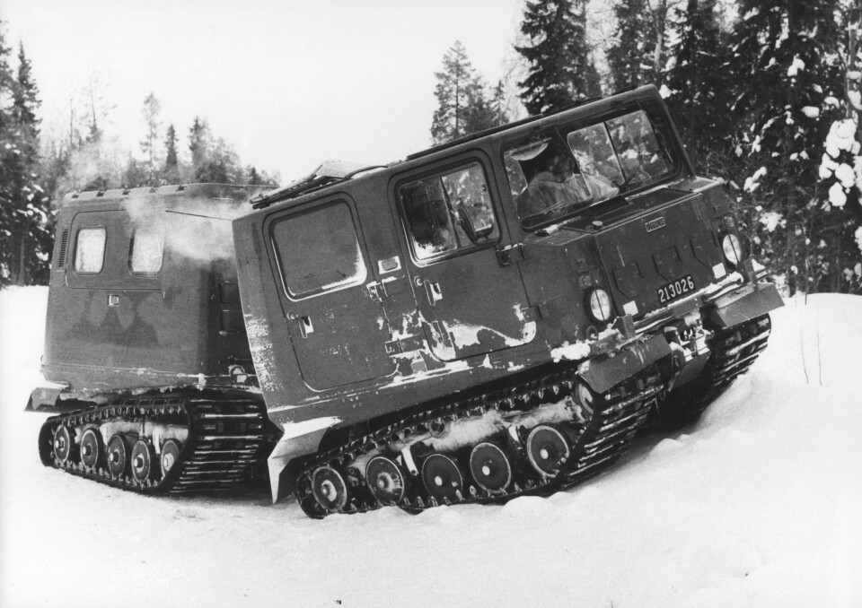 Försvarets bandvagn tar sig fram över en hög snödriva