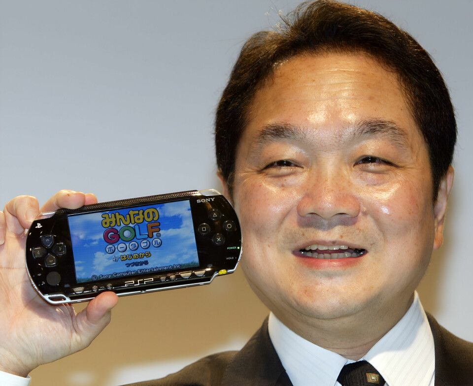 Ken Kutaragi ler och visar upp en bärbar Playstation-konsol